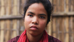 A young girl from Bangladesh wearing a red scarf