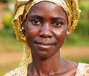 Women in yellow headscarf smiling at camera