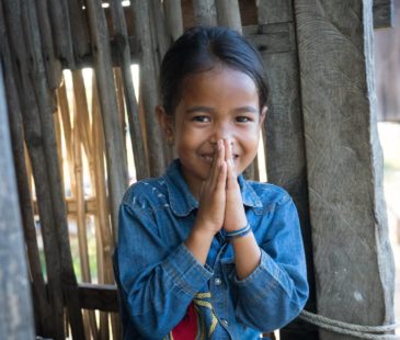A young Cambodian girl holds her hands together