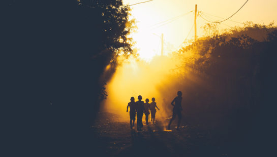 Silhouette of children running in an outdoor setting.