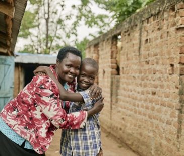 A picture of Solomon and his mother embracing outside their home