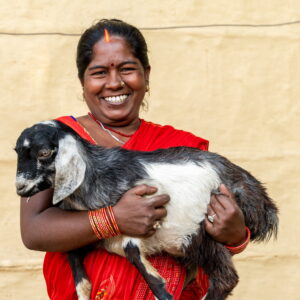 A Nepalese woman holds a goat in her arms