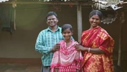 Two parents stand with their child