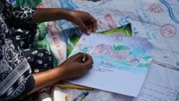A child draws an artwork on paper