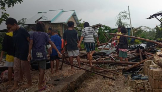 People walk through a disaster zone in Timor Leste