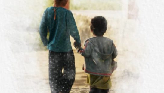 Two children walking hand in hand away from the camera