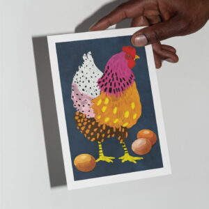 The Chicken card in hand in front of a grey background