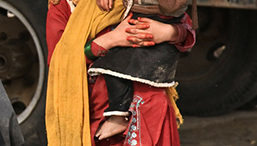 A girl holds a child in her arms