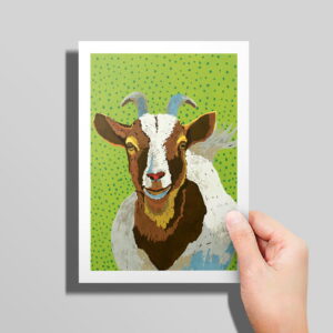 The Goats card in hand in front of a grey background