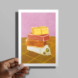 The Hand Soap card in hand in front of a grey background