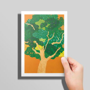 The Trees card in hand in front of a grey background