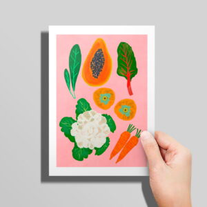 The Veggie Patch card in hand in front of a grey background