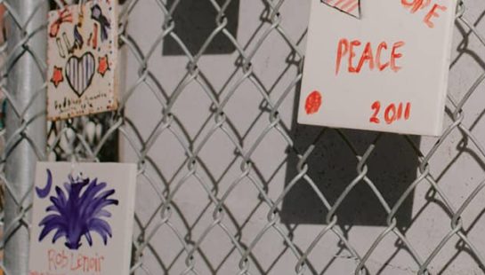 A chain link fence with cards commemorating the events of 9/11