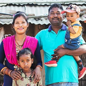 A Nepalese family pose in front of their home