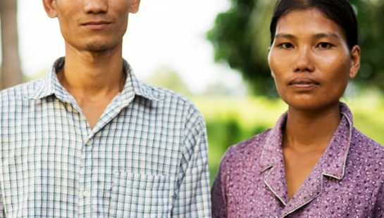 A Cambodian man and woman stand together outdoors