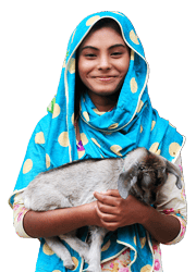 A young girl holds a baby goat in her hands