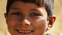 A young Nepali boy smiles to the camera