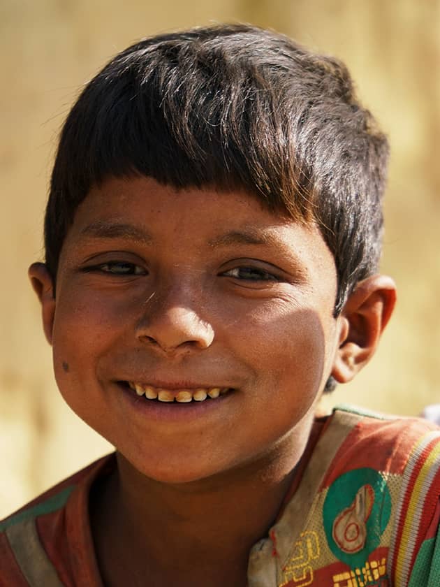 A young Nepali boy smiles to the camera