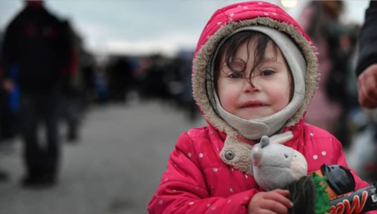 A young Ukrainian child holds a toy in hand