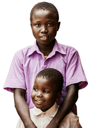 A young Ugandan boy in his purple school uniform embraces his younger brother in a white school uniform