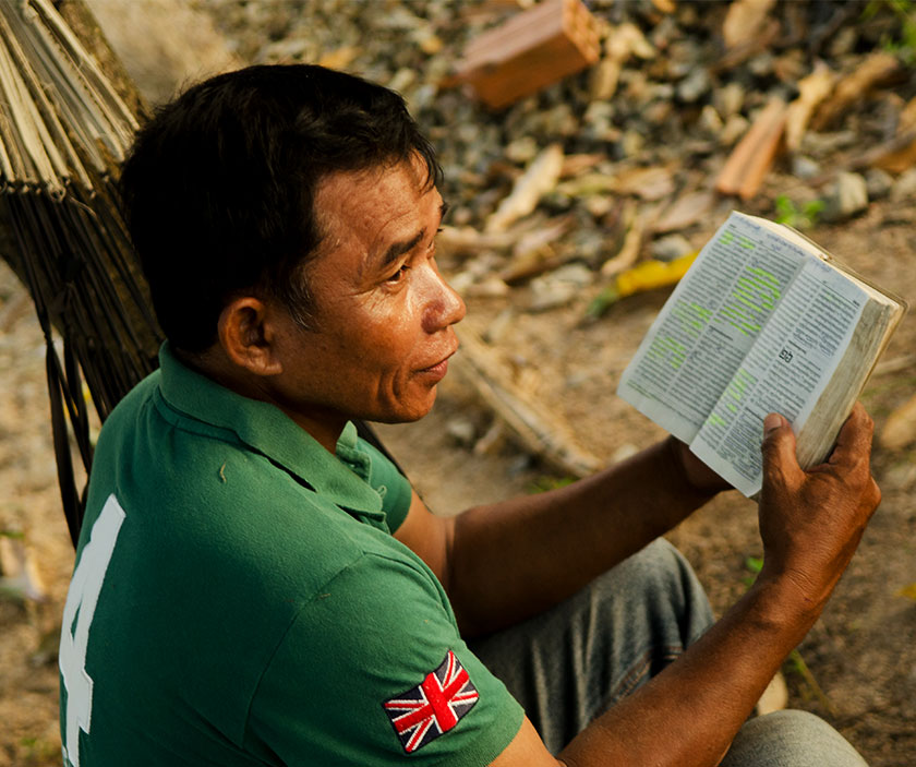 A man sits down with a Bible in hand