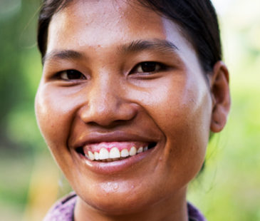 A woman wearing a purple shirt smiles