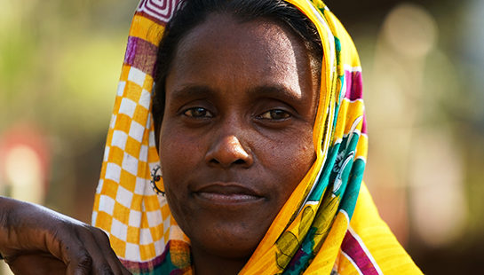A woman in a colourful yellow head scarf