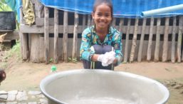 A young Cambodian girl washes her hands