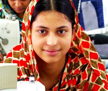 A garment worker sits at her work station