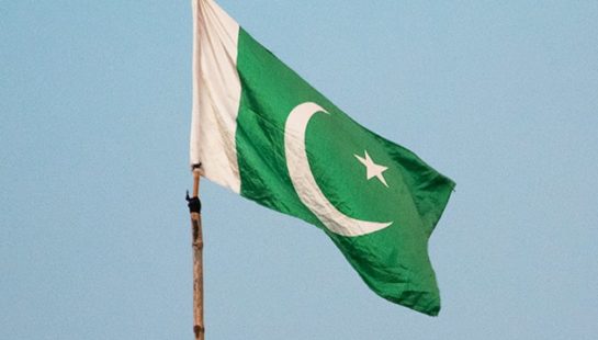 Pakistan flag on a pole flies in sky