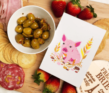 Our Better World Gift piglet card on a charcuterie board
