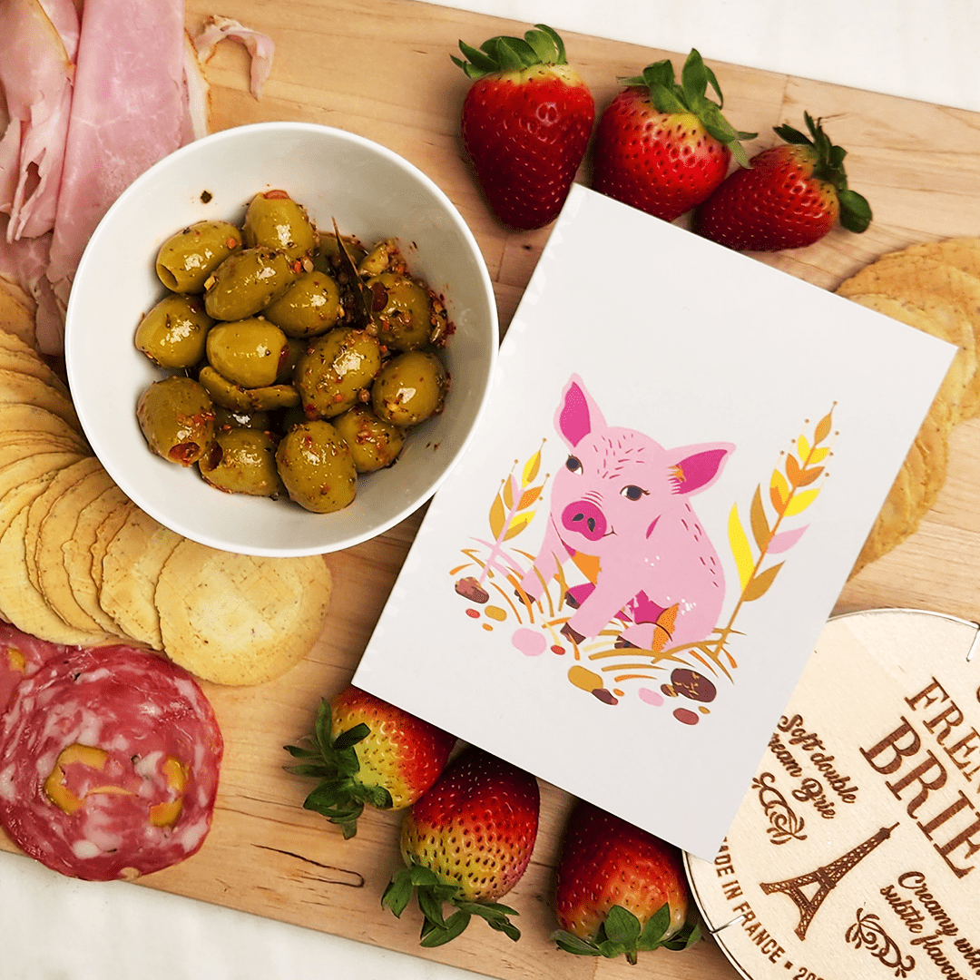 Our Better World Gift piglet card on a charcuterie board