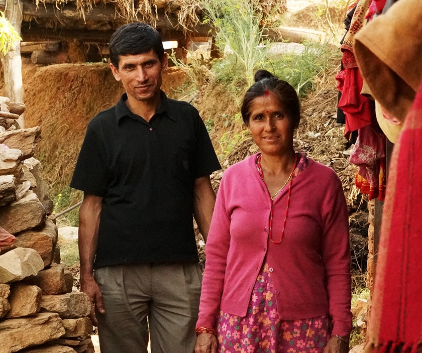 A woman stands with her son outside their home