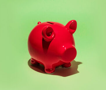 Red piggy bank on green background