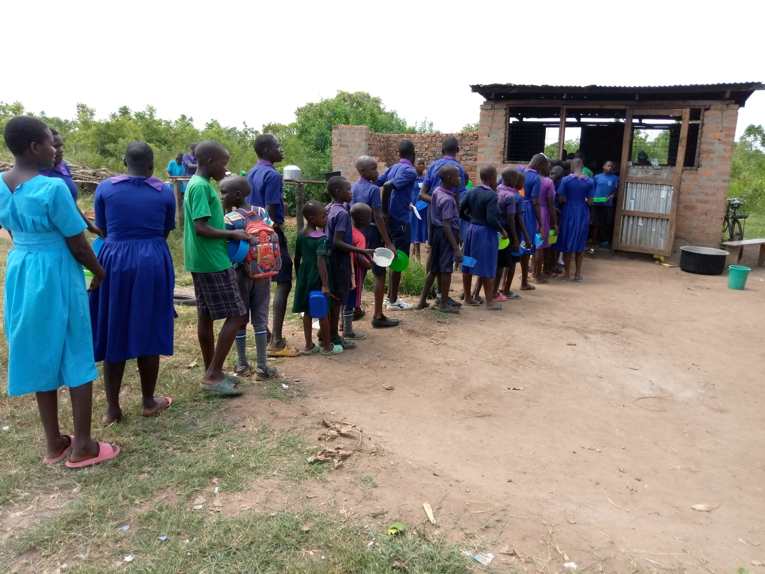 Students in Uganda queuing for meals