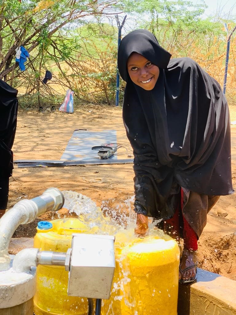 A young girl in Kenya washes her hands