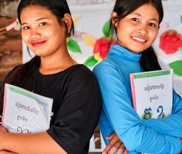 Two girls at school holding books in Cambodia