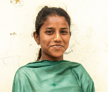 Nepali girl, Khusnaj, smiling directly at the camera. She's wearing a green shawl.